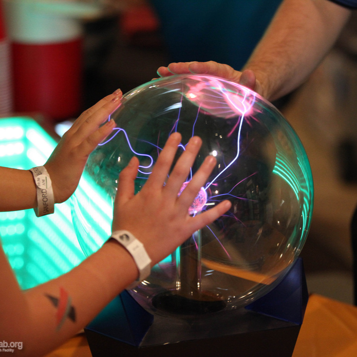 Two people interacting with a light waves exhibit at SURF