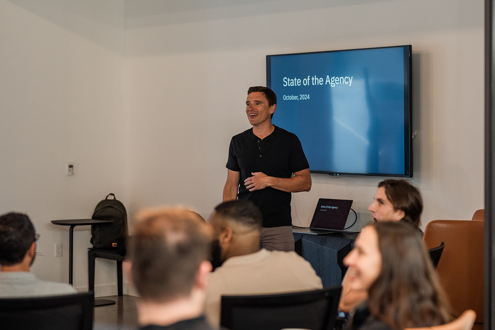 Aten's CEO, Justin presenting a slide show on a TV screen to Aten staff