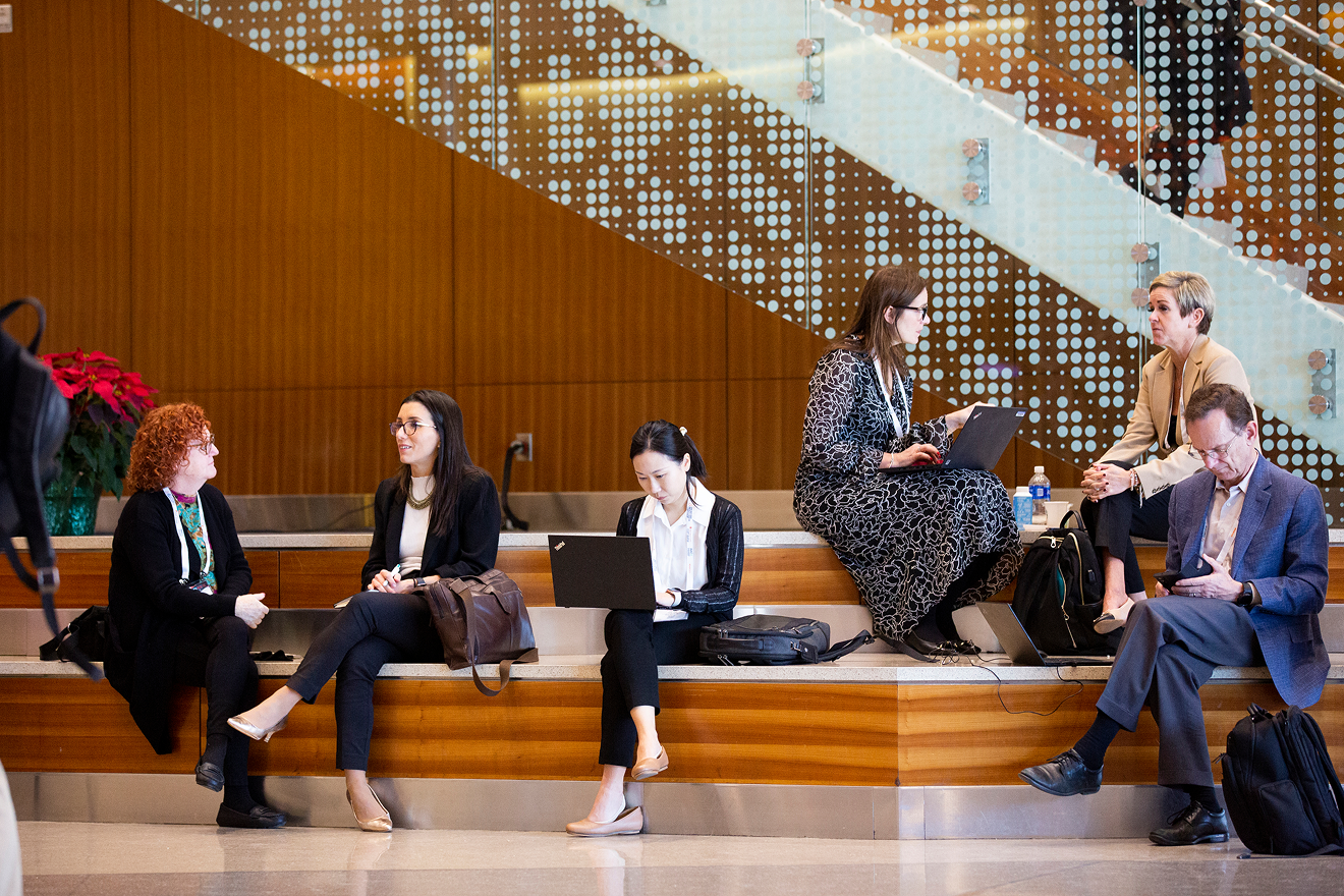 Conference attendees working and networking in a convention center hall